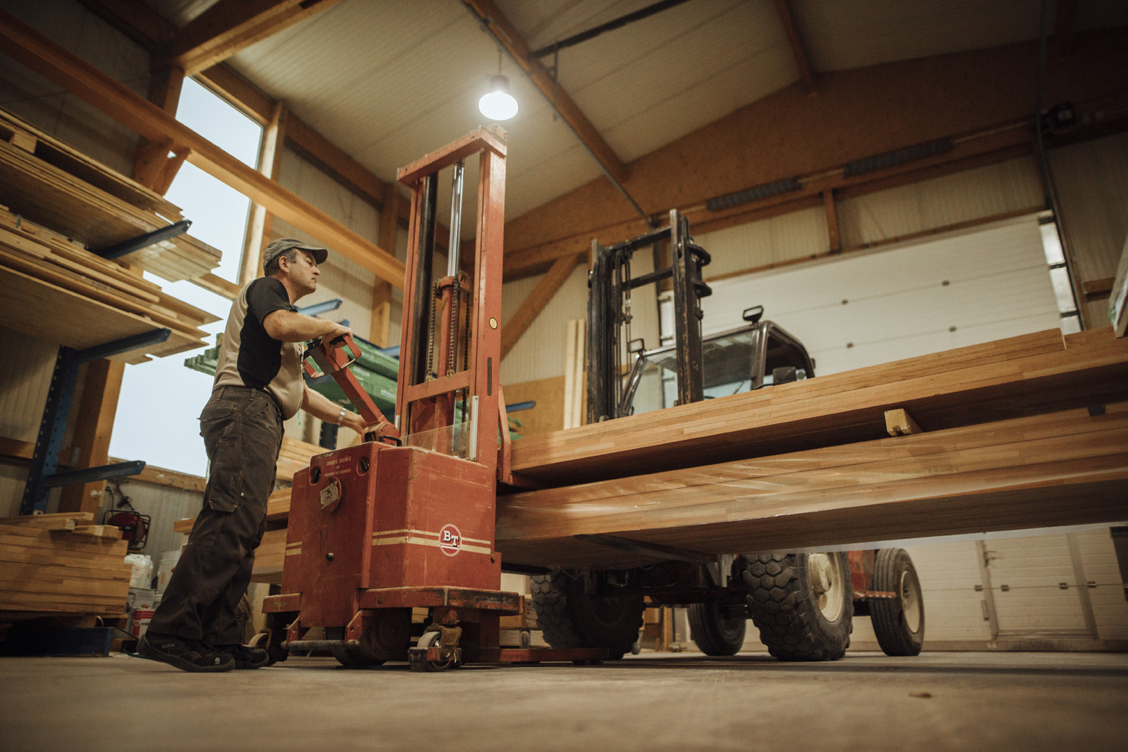 Homme qui déplace des planches en bois