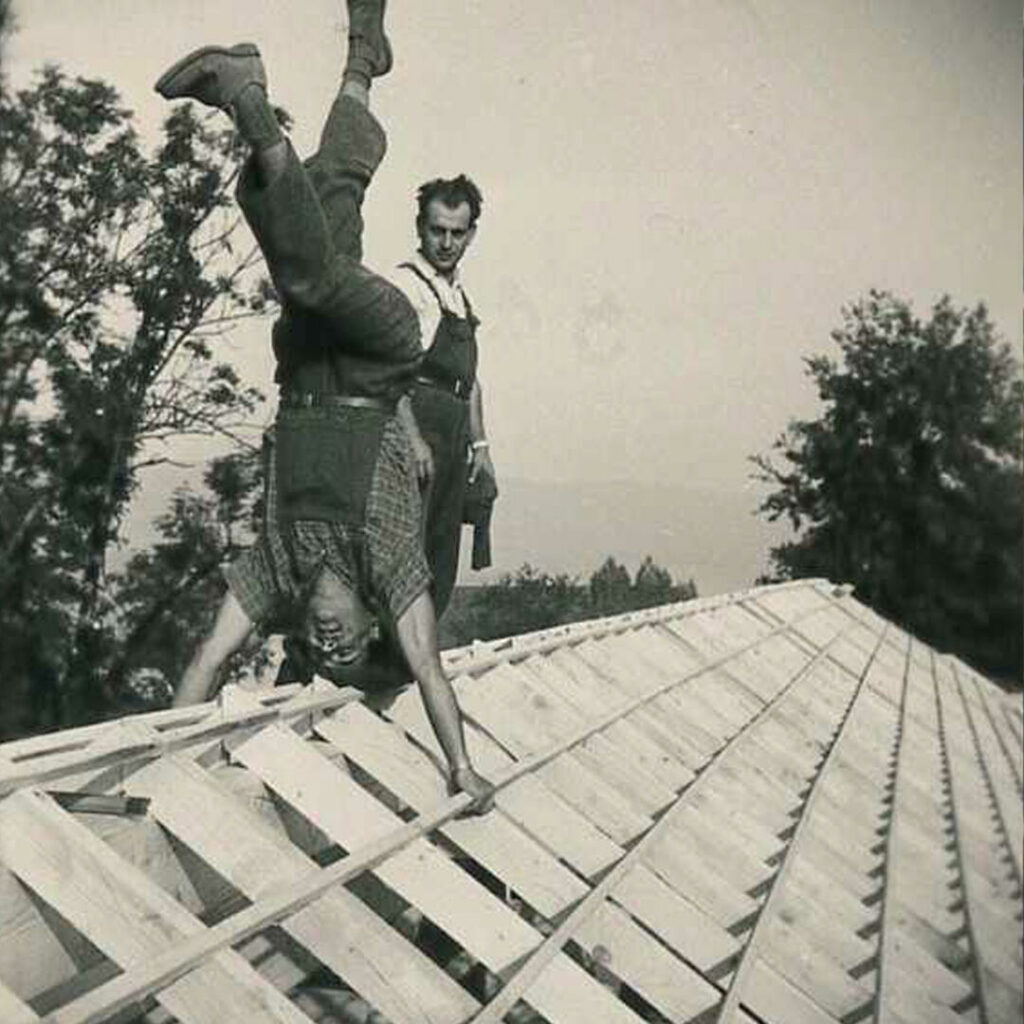 Homme faisant le poirier sur un toit ancienne photo